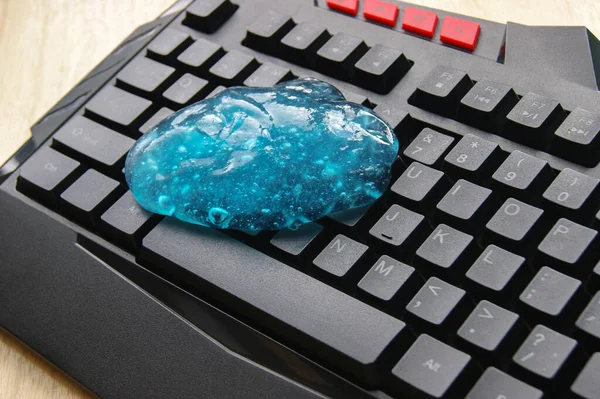 Blue soft gel cleaning dust on keyboard. Concept cleaning your computer\'s keyboard.