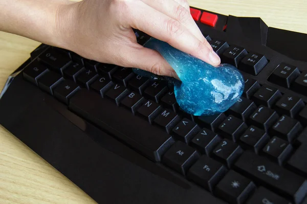 Blue soft gel cleaning dust on keyboard. Concept cleaning your computer\'s keyboard.