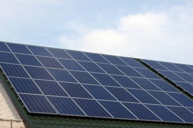 Yenilenebilir temiz yeşil enerji yeşil çatılı verimli fotovoltaik güneş panelleri ve bulutsuz mavi gökyüzü tasarrufu.