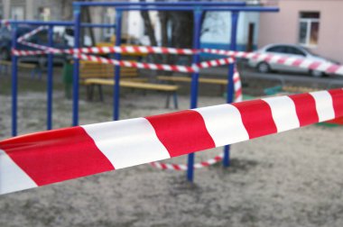 Spor sahasında beyaz ve kırmızı bariyer bandı, Coronavirus salgınıyla savaşmak için etkinleştirilen karantina kısıtlamaları nedeniyle.