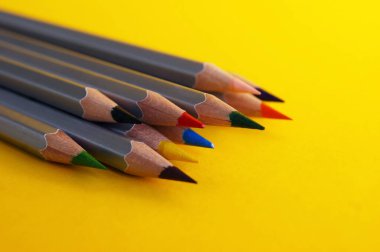 Güzel sarı bir arkaplanda bir sürü renkli kalem var. Seçici odak.