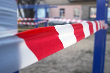 Spor sahasında beyaz ve kırmızı bariyer bandı, Coronavirus salgınıyla savaşmak için etkinleştirilen karantina kısıtlamaları nedeniyle.