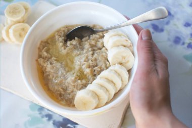 Hafif arka planda muz dilimleri olan yulaf lapası. Diyet sağlıklı besin konsepti.