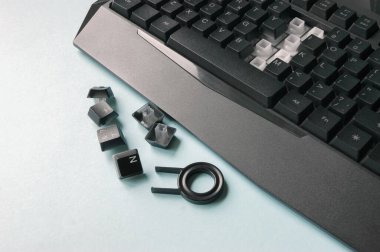 Mavi arka plandaki tuşları değiştirmek için klavye, anahtar, fırça ve anahtar. Temizlik konsepti. Ofis temizliği.