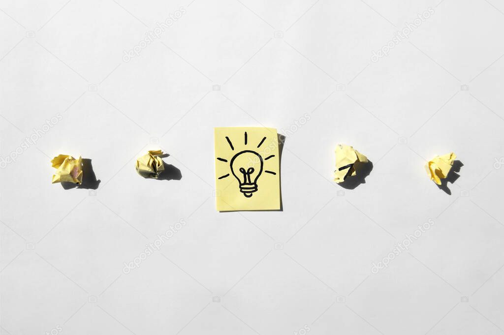 Crumpled stickers with not good ideas and solutions and a sticker with a lamp with good thoughts. Concept of business, management, markets, creativity.