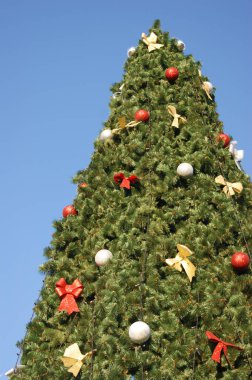 Mavi gökyüzüne karşı dev bir Noel ağacı. İyi yeni yıl ruhu..