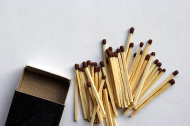 Tahta koruyucu kibritler karton kibrit kutusunun etrafına saçılmış. beyaz arkaplan.