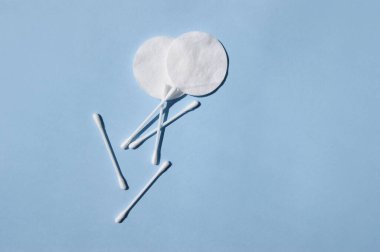 Kulak çubukları, beyaz pamuk pedler, fotokopi alanı olan mavi bir arka plan. Vücut hijyeni ve kişisel bakım kavramını.