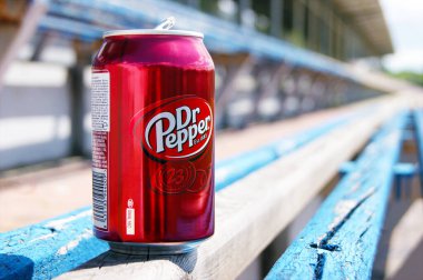 KHARKOV, UKRAINE - 12 Haziran 2020: Küçük bir stadyumdaki ahşap bir bankta duran metal bir şişe Dr. Pepper içeceği. Bulanık arkaplan.