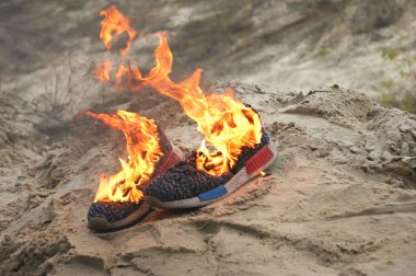 Ormanda kumların üzerinde yanan mavi spor ayakkabılar. Kavram. Spor. Kimse rahat ayakkabı giymez