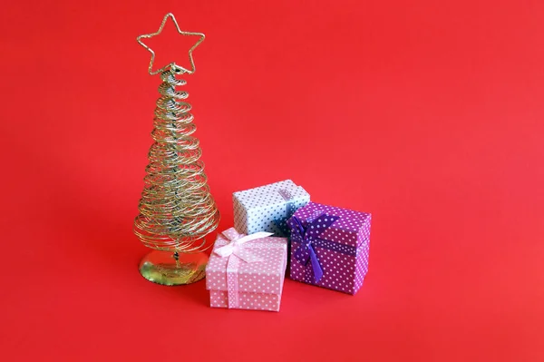 金色金属圣诞树 顶部有一颗星星 红色背景 — 图库照片