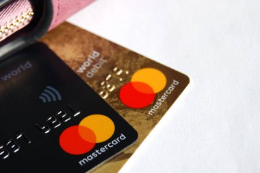 KHARKOV, UKRAINE - 8 Şubat 2020: Beyaz arka planda bir Master Card kredi kartının kapanışı. Yakınlarda bir kadın cüzdanı var.
