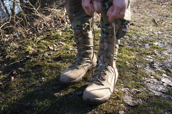 迷彩パンツの兵士が軍のブーツをレースアップ — ストック写真