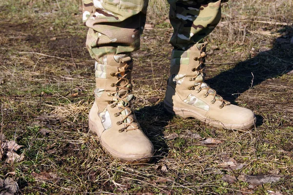 Soldier in camouflage pants and army boots.