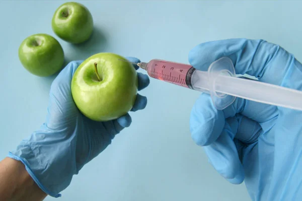 사과와 주사기와 Gmo 파란색 배경에 있습니다 채소와 과일에 Gmo — 스톡 사진