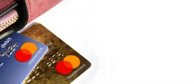 KHARKOV, UKRAINE - 8 Şubat 2020: Beyaz arka planda bir Master Card kredi kartının kapanışı. Yakınlarda bir kadın cüzdanı var.