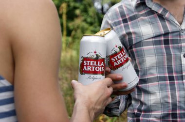 KHARKOV, UKRAINE - 23 Ağustos 2020: gençler açık havada Stella Artois birası içiyorlar. Stella Artois dünyanın en ünlü Belçika birasıdır..