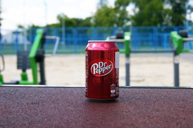 KHARKOV, UKRAINE - 12 Haziran 2020: Bir sokak spor sahasının arka planında bir metal şişe Dr Pepper içeceği. Bulanık arkaplan.