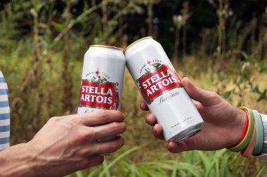 KHARKOV, UKRAINE - 23 Ağustos 2020: gençler açık havada Stella Artois birası içiyorlar. Stella Artois dünyanın en ünlü Belçika birasıdır..