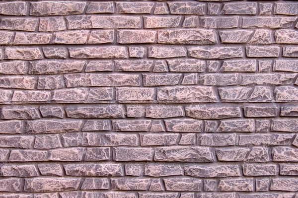 背景や質感として使用するために 明るいピンク色の塗料で描かれた古い石のフェンスの形で現代の石のフェンス — ストック写真