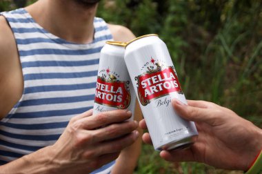 KHARKOV, UKRAINE - 23 Ağustos 2020: gençler açık havada Stella Artois birası içiyorlar. Stella Artois dünyanın en ünlü Belçika birasıdır..
