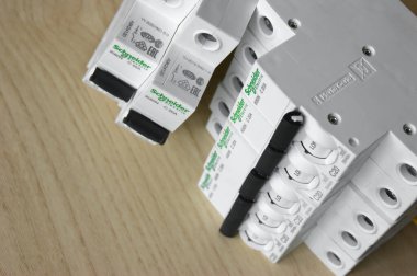 KHARKOV, UKRAINE - 22 Eylül 2020: Schneider elektrik şalterleri açık ahşap zemin üzerinde. Schneider Electric, endüstriyel işletmelerin elektrik alt kompleksleri için ekipman üreten bir Fransız elektrik mühendisliği şirketidir.
