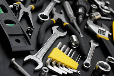 Siyah arka planda onarım için çok farklı araçlar var. Onarım ve inşaat konsepti.