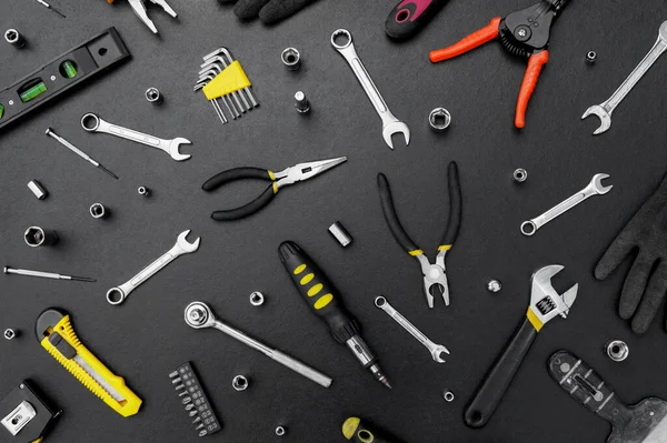 Siyah arka planda onarım için çok farklı araçlar var. Onarım ve inşaat konsepti.