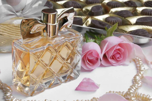 Butelka Perfum Różą Płatkami Róż Perłami Czekoladkami Jasnym Tle Perfumeria — Zdjęcie stockowe