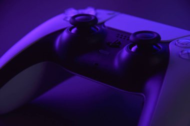 Kharkiv, Ukrayna - 10 Temmuz 2025: Beyaz Sony PlayStation 5 ve karanlık masa üzerindeki denetleyici.