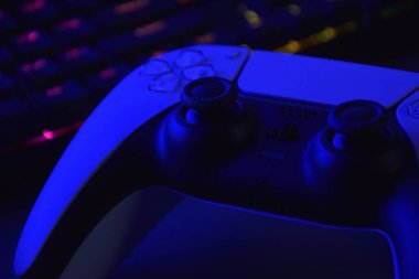 Kharkiv, Ukrayna - 10 Temmuz 2025: Beyaz Sony PlayStation 5 ve karanlık masa üzerindeki denetleyici.