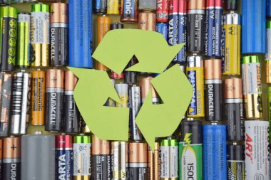 Kharkiv, Ukrayna - 20 Temmuz 2025: Kullanılmış AA bataryalar ve çevresel ve toprak toksik bataryaların yeşil arka planda düzgün bir şekilde imha edilmesi.