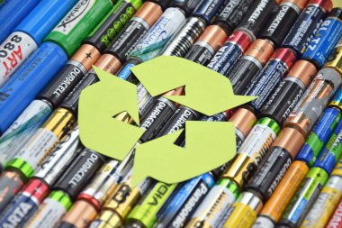 Kharkiv, Ukrayna - 20 Temmuz 2025: Kullanılmış AA bataryalar ve çevresel ve toprak toksik bataryaların yeşil arka planda düzgün bir şekilde imha edilmesi.