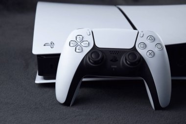 Kharkiv, Ukrayna - 10 Temmuz 2025: Beyaz Sony PlayStation 5 ve karanlık masa üzerindeki denetleyici.