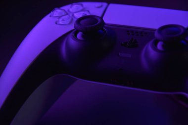 Kharkiv, Ukrayna - 10 Temmuz 2025: Beyaz Sony PlayStation 5 ve karanlık masa üzerindeki denetleyici.