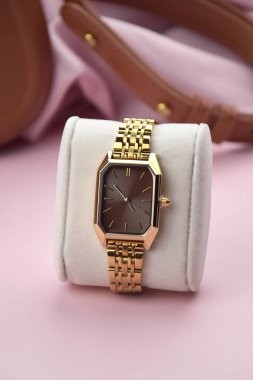 Pembe arka plandaki kadınlar için en az moda kol saati. Moda ve tarz.