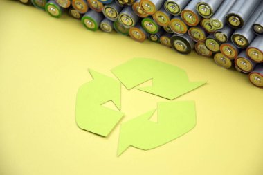 Kullanılmış AA bataryalar ve çevresel atık ve yeşil arka planda toprak toksik bataryalar. Zararlı ve geri dönüşümlü nesnelerin işlenmesi kavramı.