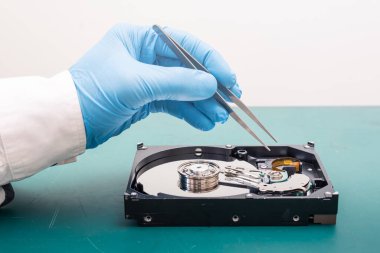 Laboratuvardaki sabit diskin içinde tamir yapan teknisyenin soyut görüntüsü. Veri, donanım, teknisyen ve teknoloji kavramı.