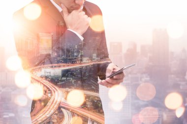 Gündoğumu sırasında akıllı telefon kullanan bir iş adamının şehir görüntüsüyle çifte pozlama görüntüsü. Modern hayat, iş, şehir hayatı ve internet kavramı..