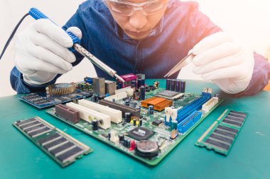 Asyalı teknisyenin laboratuarda lehimleyerek bilgisayar ana tahtasını tamir edişinin soyut görüntüsü. Bilgisayar donanımı, onarım, güncelleme ve teknoloji kavramı