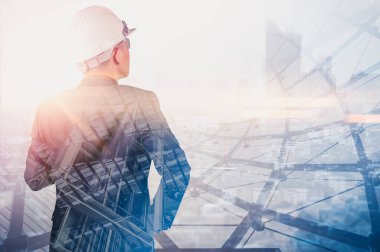 Gündoğumu sırasında kentin görüntüsüyle örtüşen mühendisin çift pozlama görüntüsü. Mühendislik, inşaat, şehir hayatı ve gelecek kavramı..