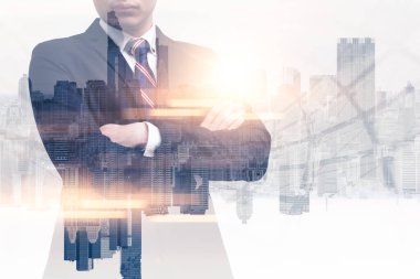 Gündoğumu sırasında kentin görüntüsüyle örtüşen iş adamının çifte pozlama görüntüsü. Modern hayat, iş, şehir hayatı ve internet kavramı..