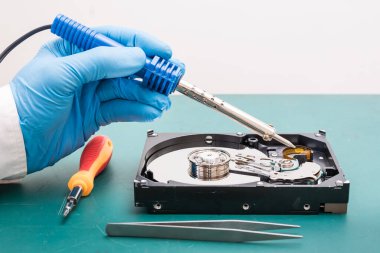 Teknisyenin masasındaki sabit diskin içindeki soyut görüntü ve bir bilgisayar anakart bileşeni. Veri, donanım ve bilgi teknolojisi kavramı