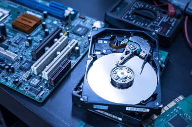Teknisyenin masasındaki sabit diskin içindeki soyut görüntü ve bir bilgisayar anakart bileşeni. Veri, donanım ve bilgi teknolojisi kavramı