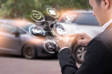 İş adamının soyut görüntüsü, akıllı telefonundaki holograma ve bulanık araba kazasına işaret ediyor. Şeylerin iletişim, ağ, sigorta, finans ve internet kavramı.