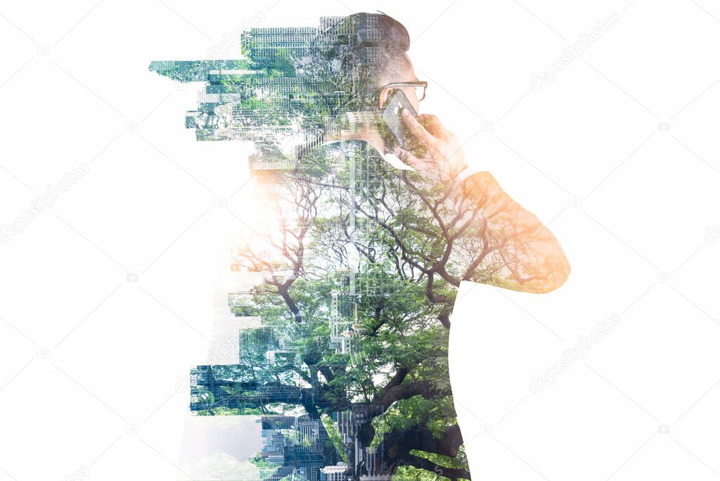 businessman using a smartphone during sunrise overlay with nature and cityscape image. The concept of telecommunication, technology, 5g and internet of things.
