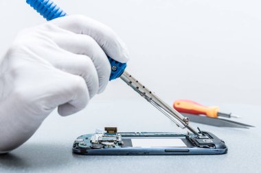 Asyalı teknisyen laboratuvarda akıllı telefonun ana kartını fotokopi aletiyle onarıyor. bilgisayar donanımı, cep telefonu, elektronik, onarım, güncelleme ve teknoloji kavramı.