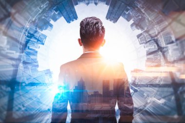 Gündoğumu sırasında kentin görüntüsüyle örtüşen iş adamının çifte pozlama görüntüsü. Modern hayat, iş, şehir hayatı ve internet kavramı..