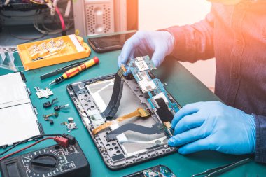 Asyalı teknisyenin laboratuvarda tornavidayla tablet tamir ederken ki soyut görüntüsü. bilgisayar donanımı, cep telefonu, elektronik, onarım, güncelleme ve teknoloji kavramı.
