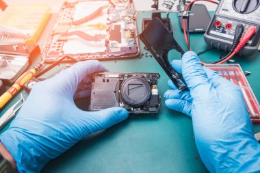 Laboratuvarda tornavida tarafından dijital kameranın içinde tamir edilen Asyalı teknisyenin soyut görüntüsü. bilgisayar donanımı, cep telefonu, elektronik, onarım, güncelleme ve teknoloji kavramı.